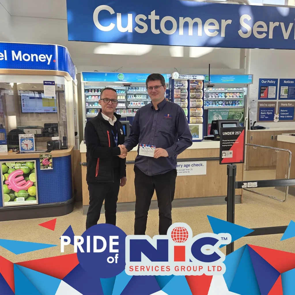 Paul Robertson receiving his Pride of NIC Award certificate with a handshake at Tesco Consett Genesis Extra customer service desk