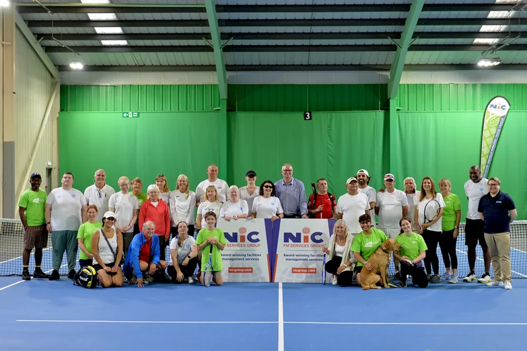Players and volunteers of the 2026 NIC Yorkshire Visually Impaired Tennis League posing with a NIC FM Services Group banner